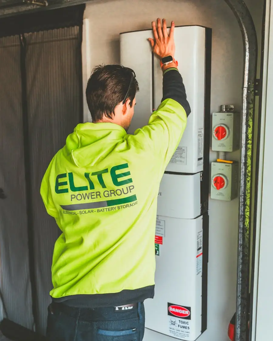 Tekniker installerar hemlagringssystem med batteri och inverter på garage-vägg